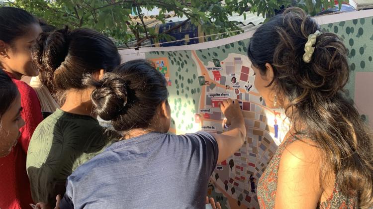 Community gathering; women pointing to map